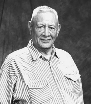 An elder gentleman smiles at the camera