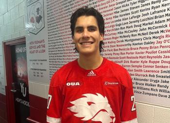 Lucas Eagle is pictured wearing a red jersey with a white lion logo on it.