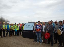 People gather around a new sign marking the location of the new solar farm in Edmonoton.