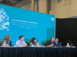 People sit at a table to present at COP15 in Montreal