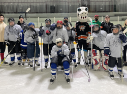 Young hockey players gather on the ice for a group photo.