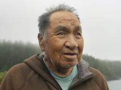 A man stands on a misty coastal outlook over the bay at Yuquot, Friendly Cove, in Nootka Sound, B.C.